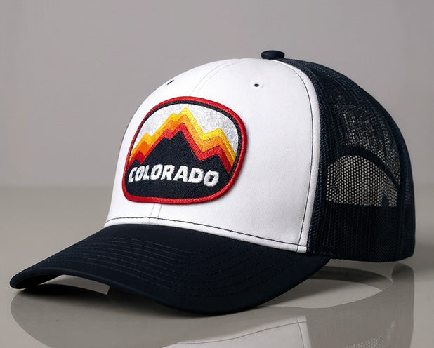 Colorado Peaks trucker hat in navy and white with mountain patch on front