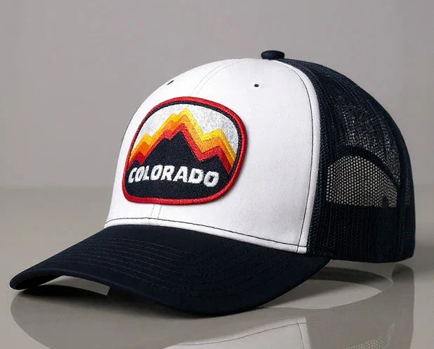 Colorado Peaks trucker hat in navy and white with mountain patch on front