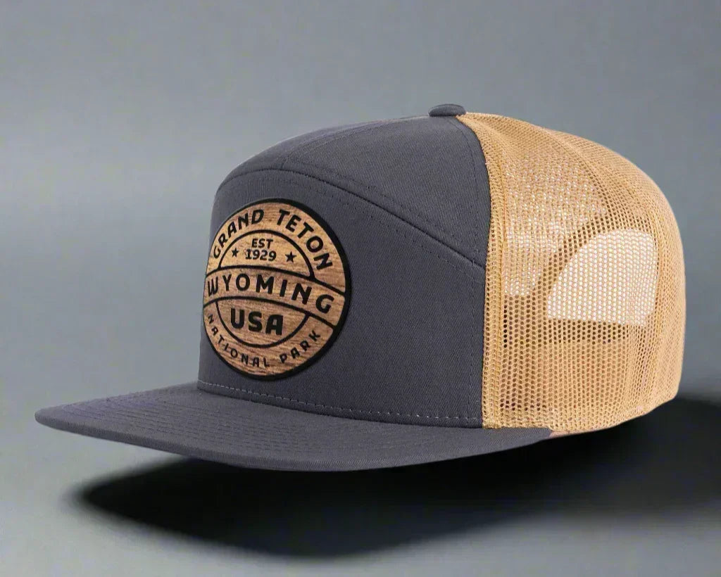 Charcoal and gold mesh Grand Teton Wyoming trucker hat with round patch logo