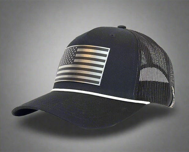 Black mesh trucker hat with chrome USA flag patch on front and white accent piping