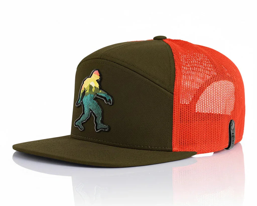 Green and orange cap with embroidered design on a white background