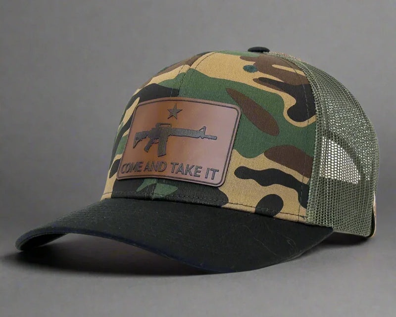 Camouflage baseball cap with 'COME AND TAKE IT' patch on a white background