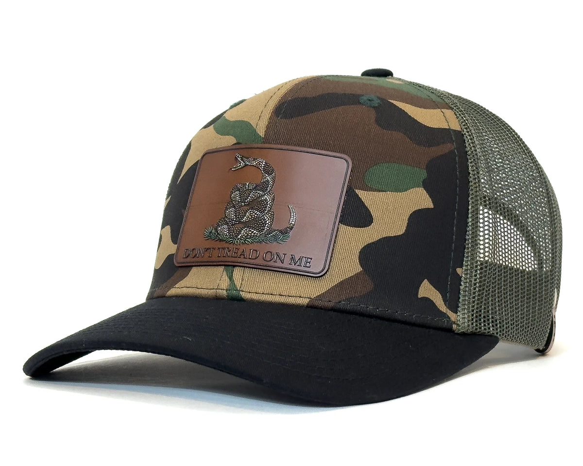 Camouflage baseball cap with a leather patch on a white background