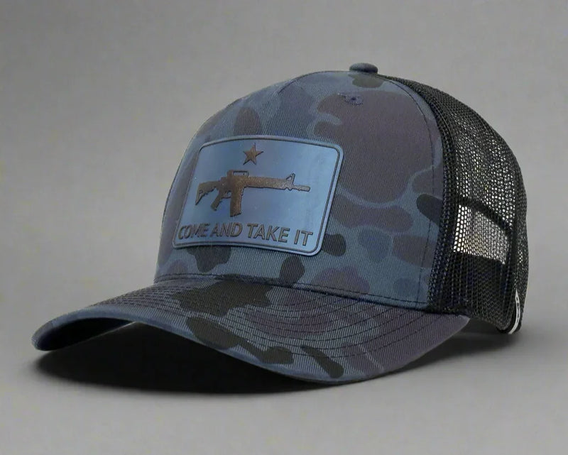Camouflage cap with a patch featuring an rifle and 'COME AND TAKE IT' text on a gray background