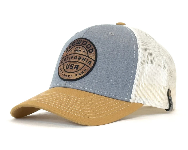 Trucker hat with blue front panel, beige bill, and white mesh back on a white background