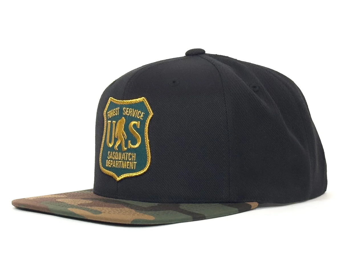 Black cap with a gold and green logo on a white background