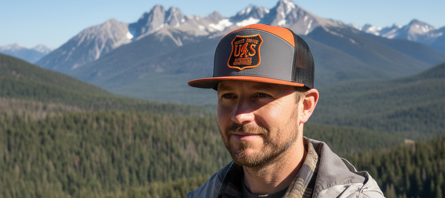Man wearing a cap with a mountainous landscape in the background