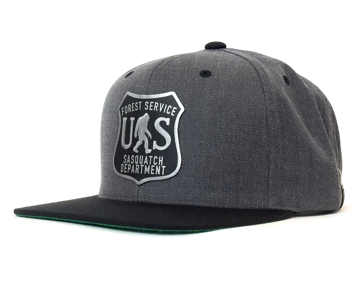 Gray cap with a Forest Service Sasquatch Department logo on a white background