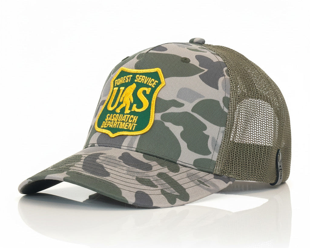 Camouflage cap with a yellow and green patch on a white background