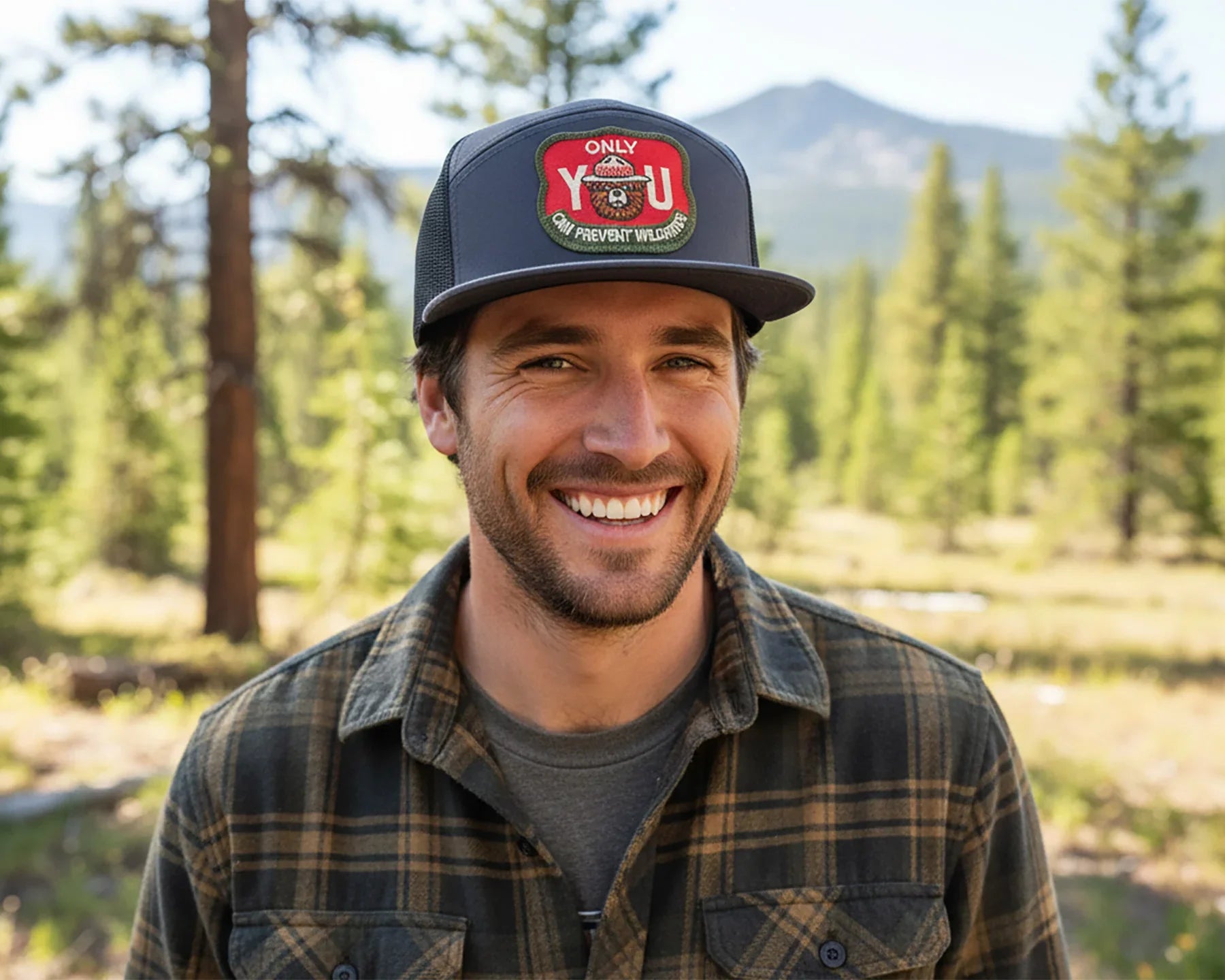 Man wearing a cap with a logo in a forest setting