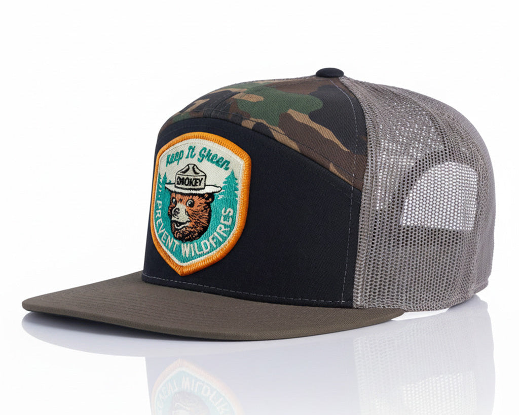Camouflage and black trucker hat with a patch on a white background