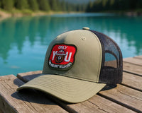 Green cap with a patch on a wooden dock by a lake with mountains in the background