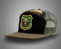Camouflage and green trucker hat with a patch on a white background