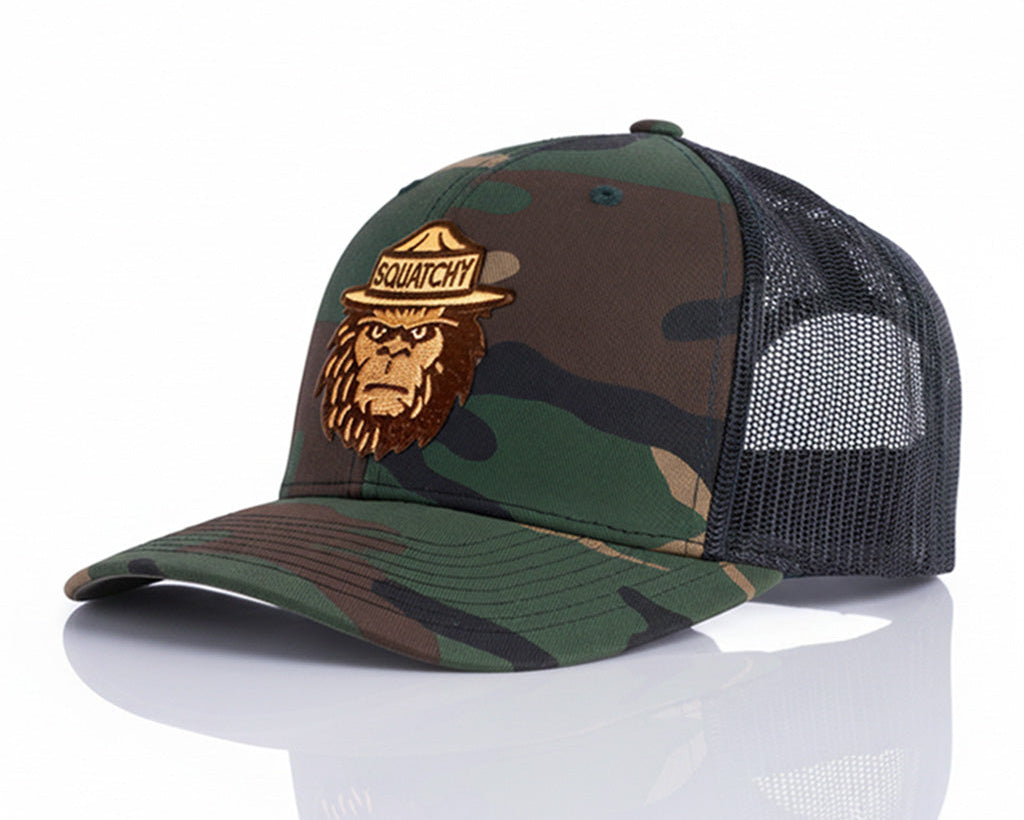 Camouflage baseball cap with a patch featuring an animal and text on a white background