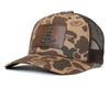 Camouflage trucker hat with a patch on a brown background