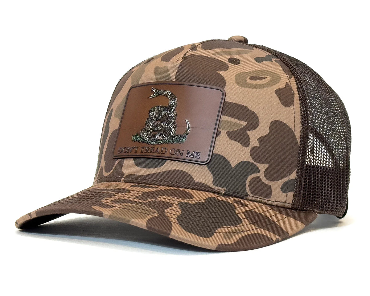 Camouflage trucker hat with a patch on a brown background