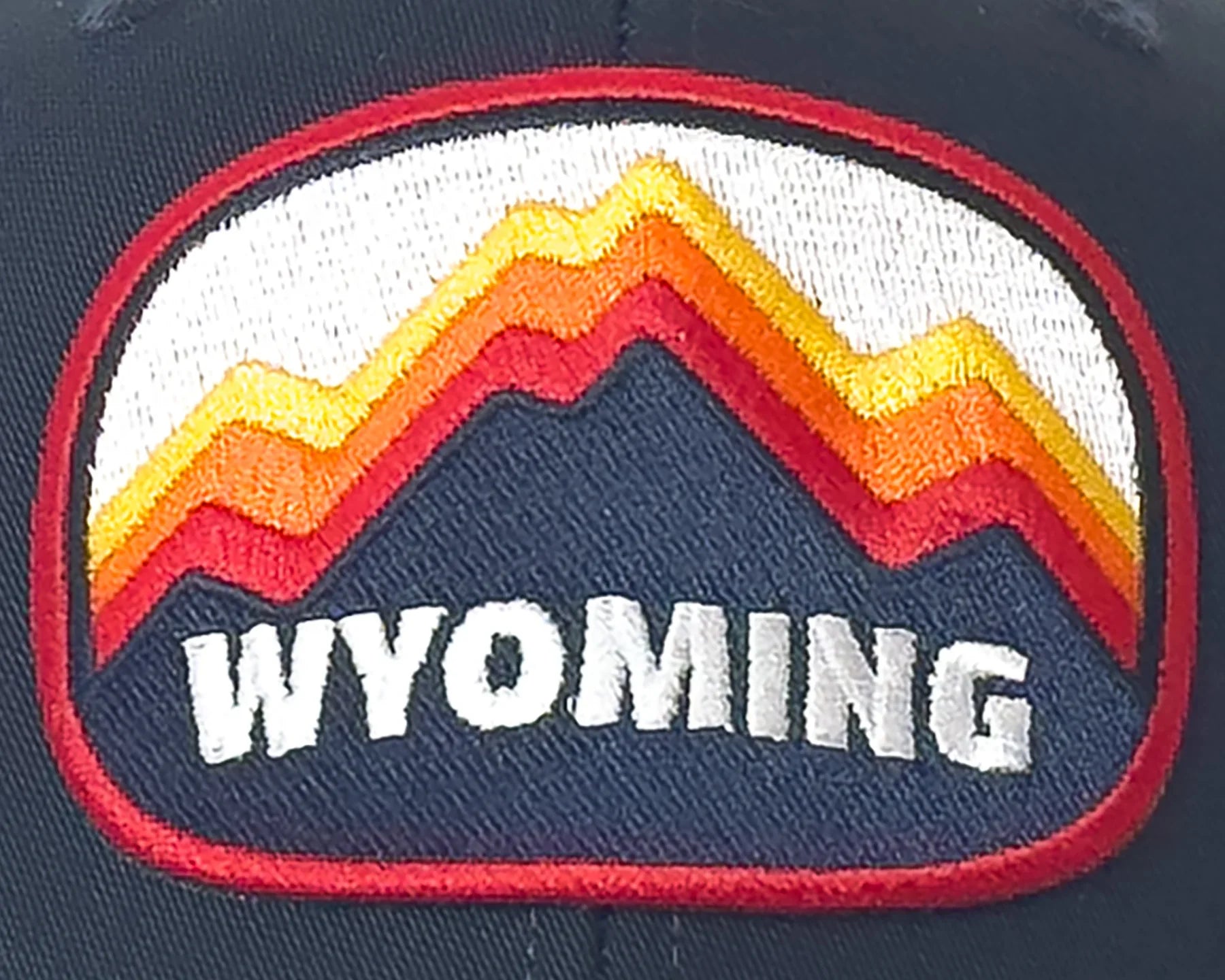 Cap with Wyoming logo featuring colorful mountains on a dark background