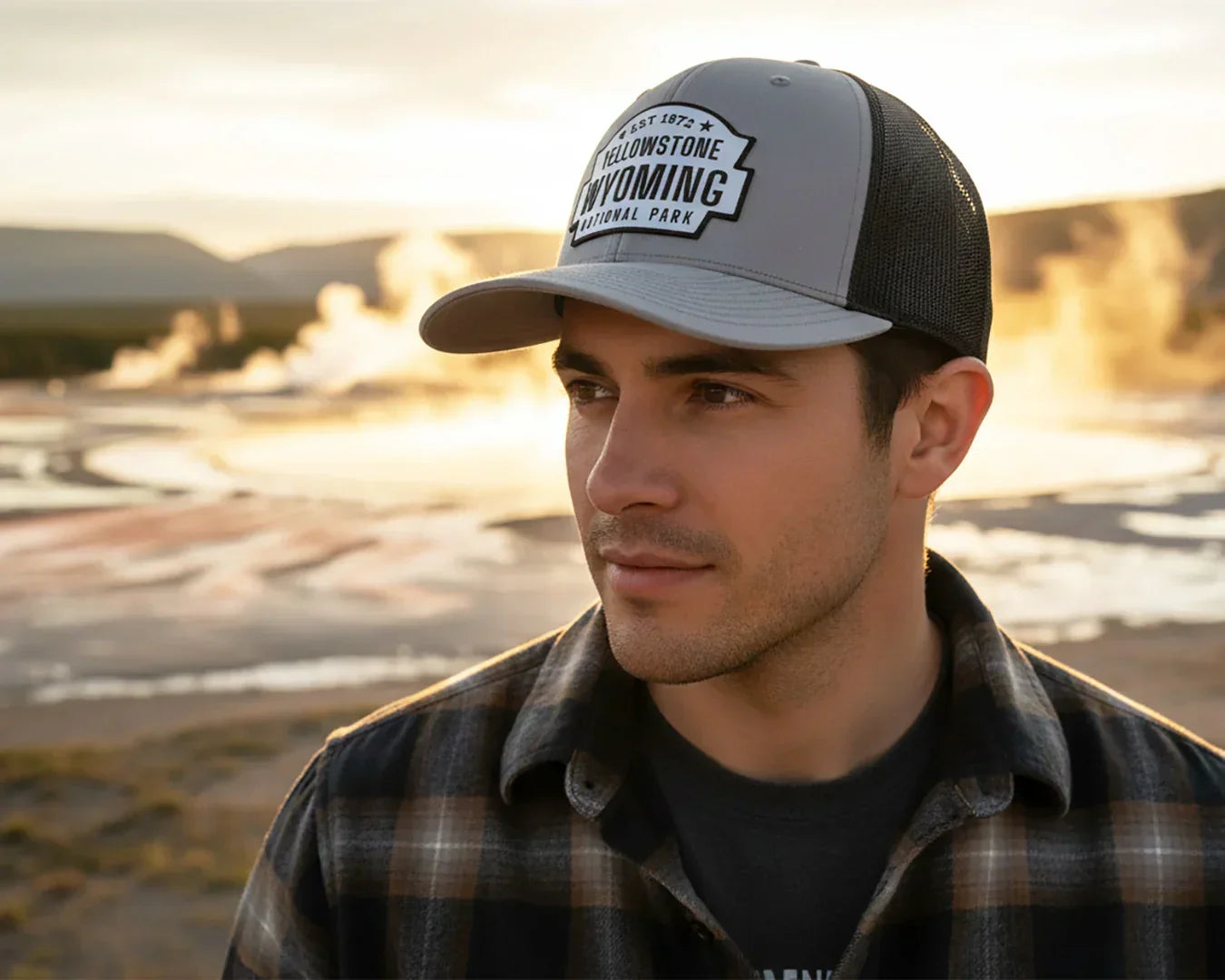 Man wearing a Yellowstone Wyoming cap in a scenic outdoor setting