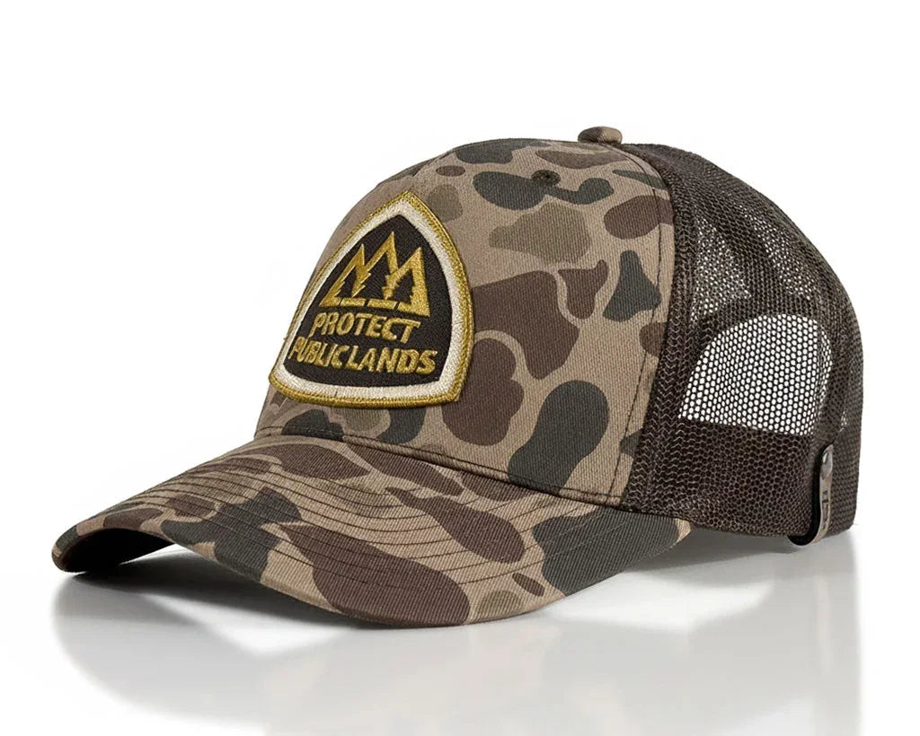 A camouflage trucker hat with a brown mesh back and a front patch reading 'PROTECT PUBLIC LANDS'.