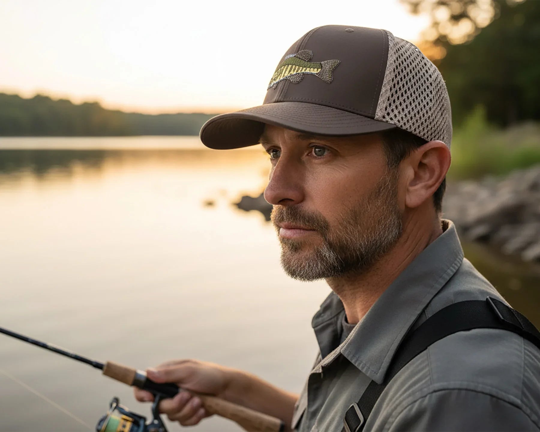 Man fishing by a lake with sunset in the background